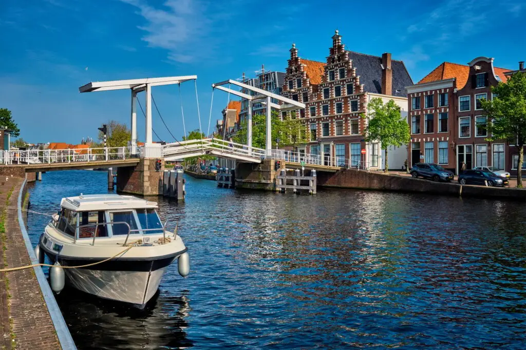 Spaarne river with boat and Gravestenenbrug bridge in Haarlem, N