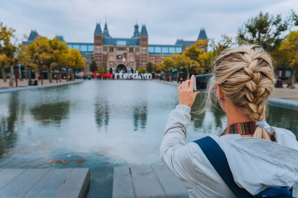 Ana Sayfa 30 Woman tourist taking photo of the Rijksmuseum in Amsterdam on the mobile phone. Travel in Europe